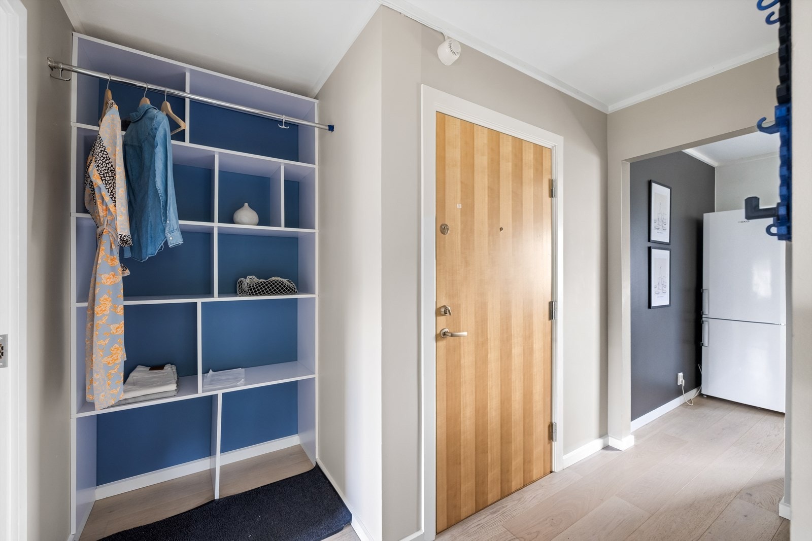 Velkommen inn til en hyggelig entré lyst parkettgulv, malte veggflater og rikelig med veggplass til knagger og andre smarte garderobesystemer. Entrédør fra 2017. Galleribilde