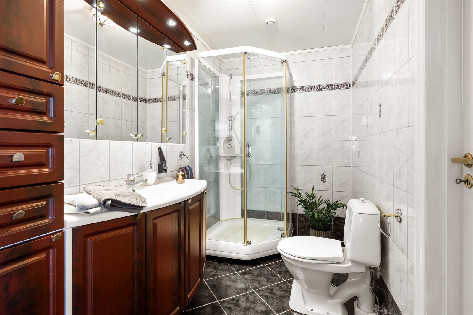 Badet i hovedetasjen har flislagt gulv med elektriske varmekabler, dusjkabinett og servant med innredning. Galleribilde