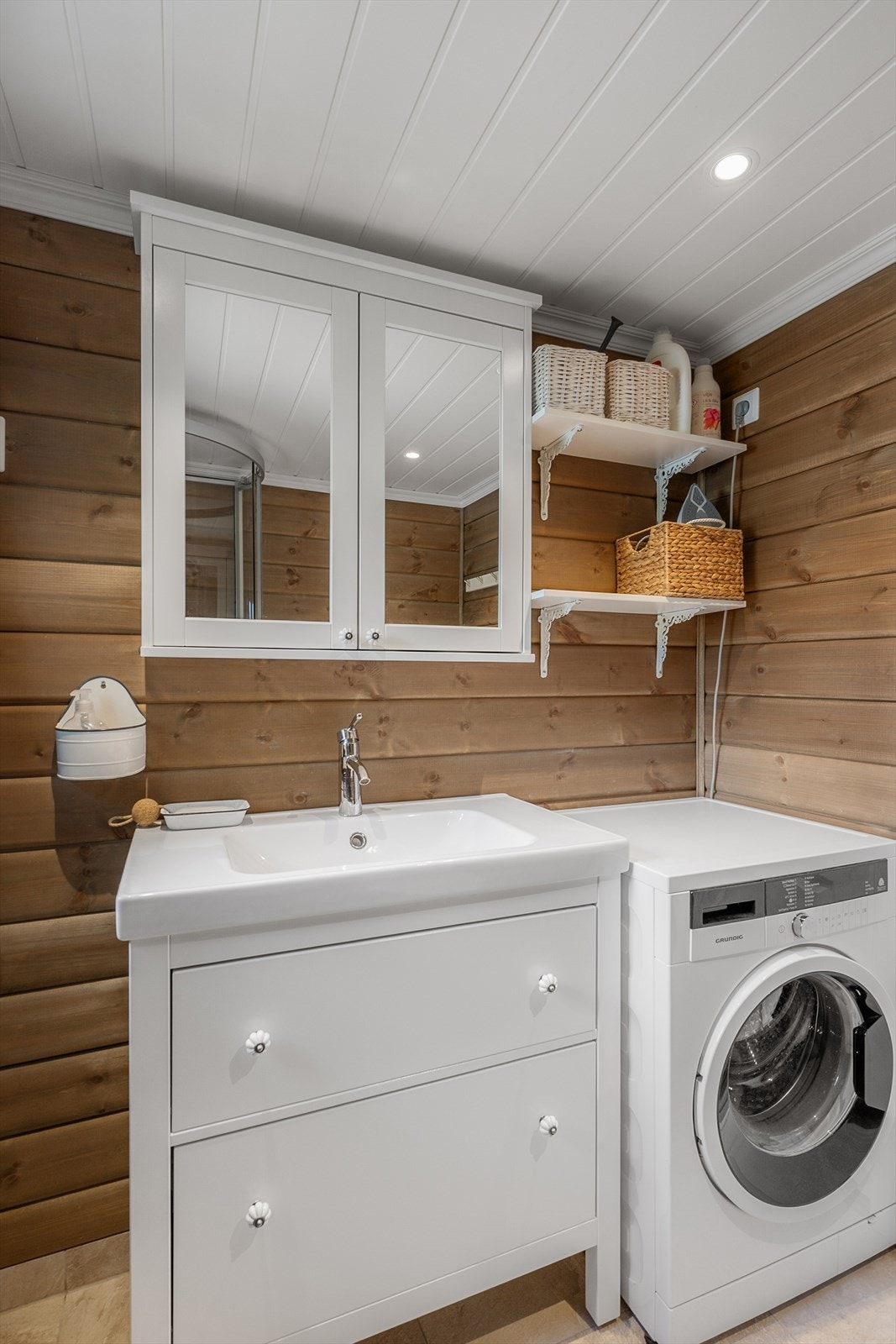 Badet har dusjkabinett, servant med underskap og opplegg for vaskemaskin. Galleribilde