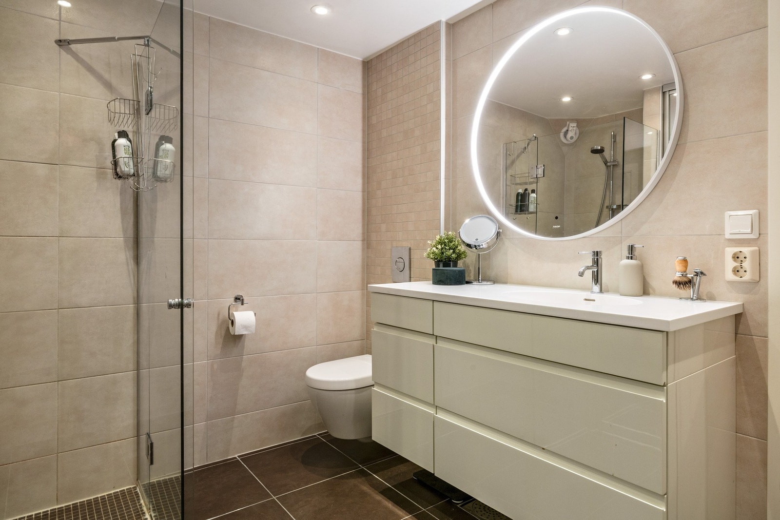 Badet har innredning med nedfelt servant, romslig oppbevaring og veggmontert toalett Galleribilde