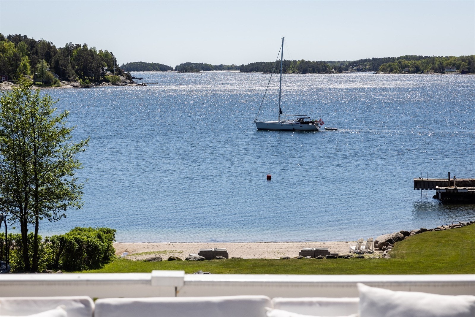 Utsikt fra terrassen mot den private stranden og bryggen. Galleribilde