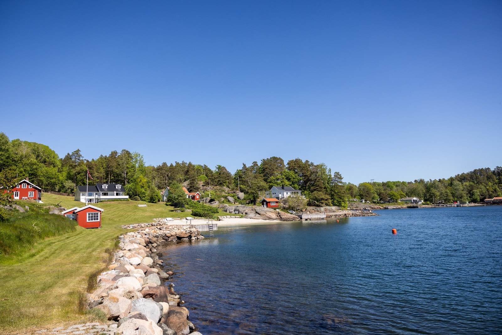 Her kan du boltre deg på en stor parkmessig gressplen, bade og nyte strandlivet fra en egen herlig sandstrand, legge båten trygt inntil egen brygge eller hva med en rusletur langs strandkanten og videre ut på steinbrygga hvor de siste solstråler kan nyte Galleribilde