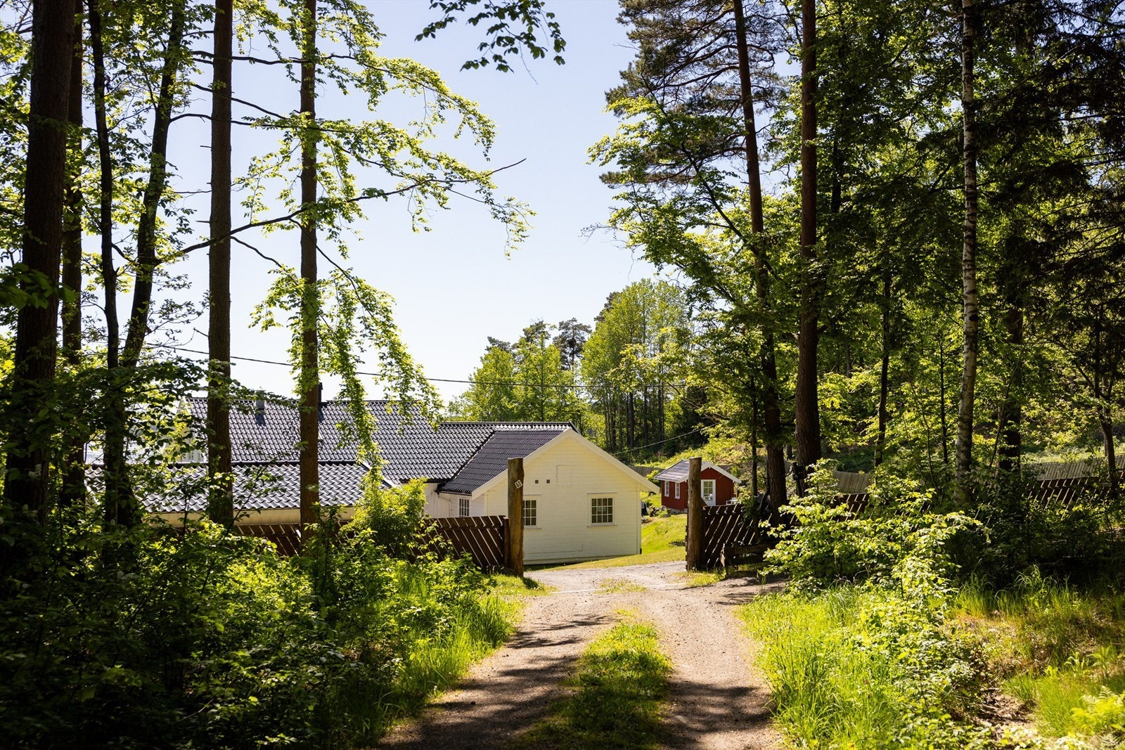 Bak et hyggelig gjerde, gjennom en port, ligger Fuglevik Galleribilde