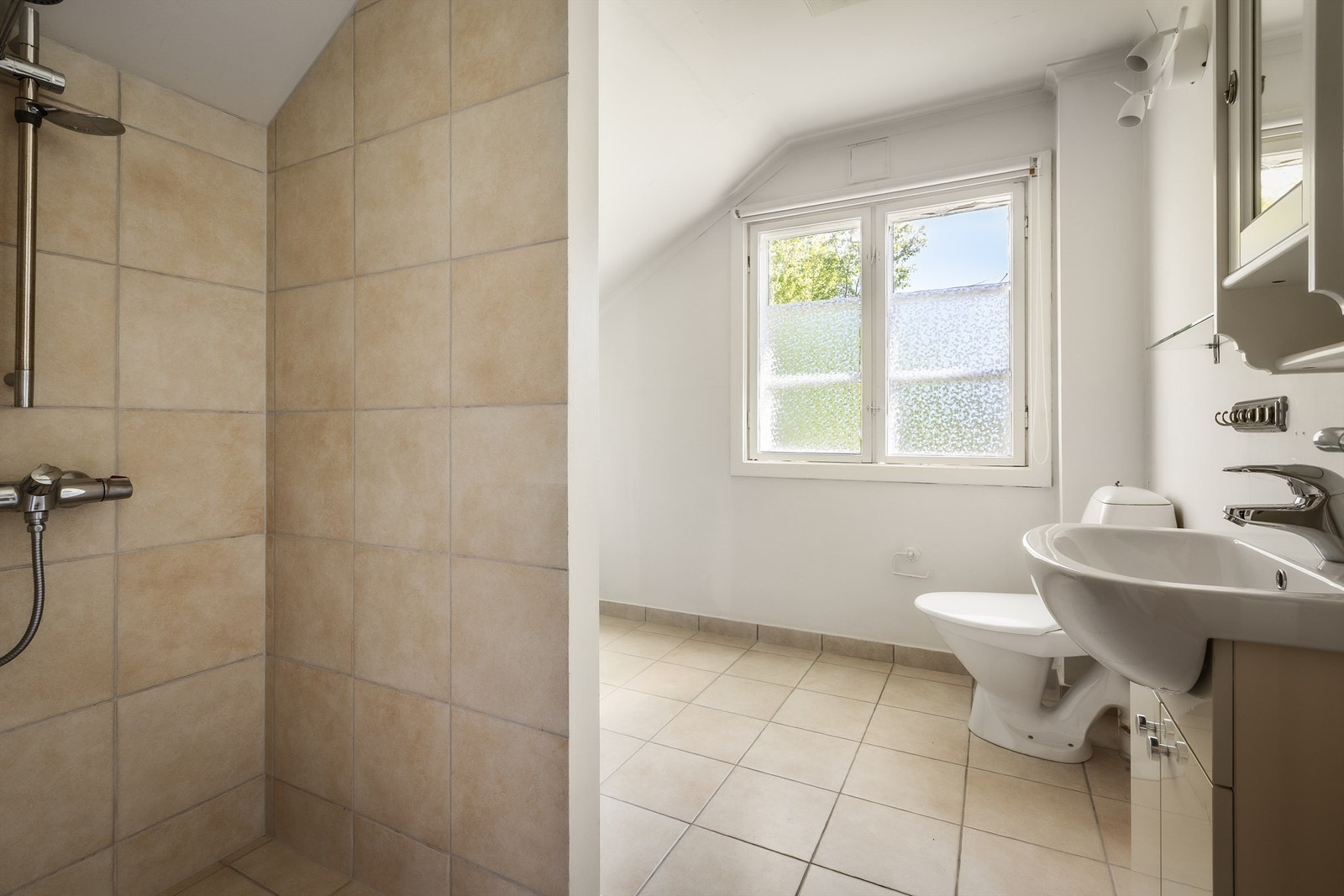 Badet i andre etasje har flislagt gulv og fliser i dusjsonen. Galleribilde
