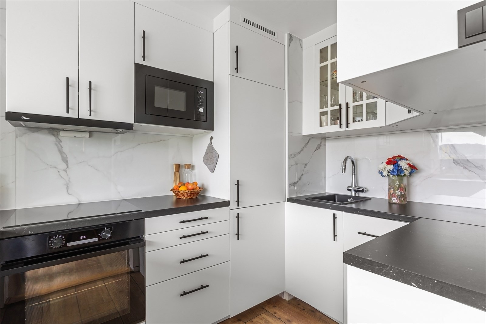 Kjøkken med en moderne og stilren utforming. Kjøkkeninnredning oppgradert i 2025. Innredningen består av slette fronter i lyse toner kombinert med mørk laminert benkeplate med nedfelt vaskekum, som gir et elegant uttrykk. Galleribilde
