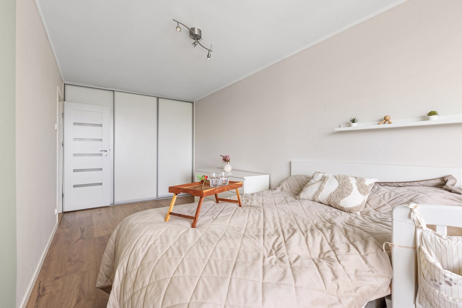 Lyst og fint soverom med laminat og lyse, harmoniske fargetoner. Praktisk skyvedørsgarderobe sørger for gode oppbevaringsmuligheter. Galleribilde