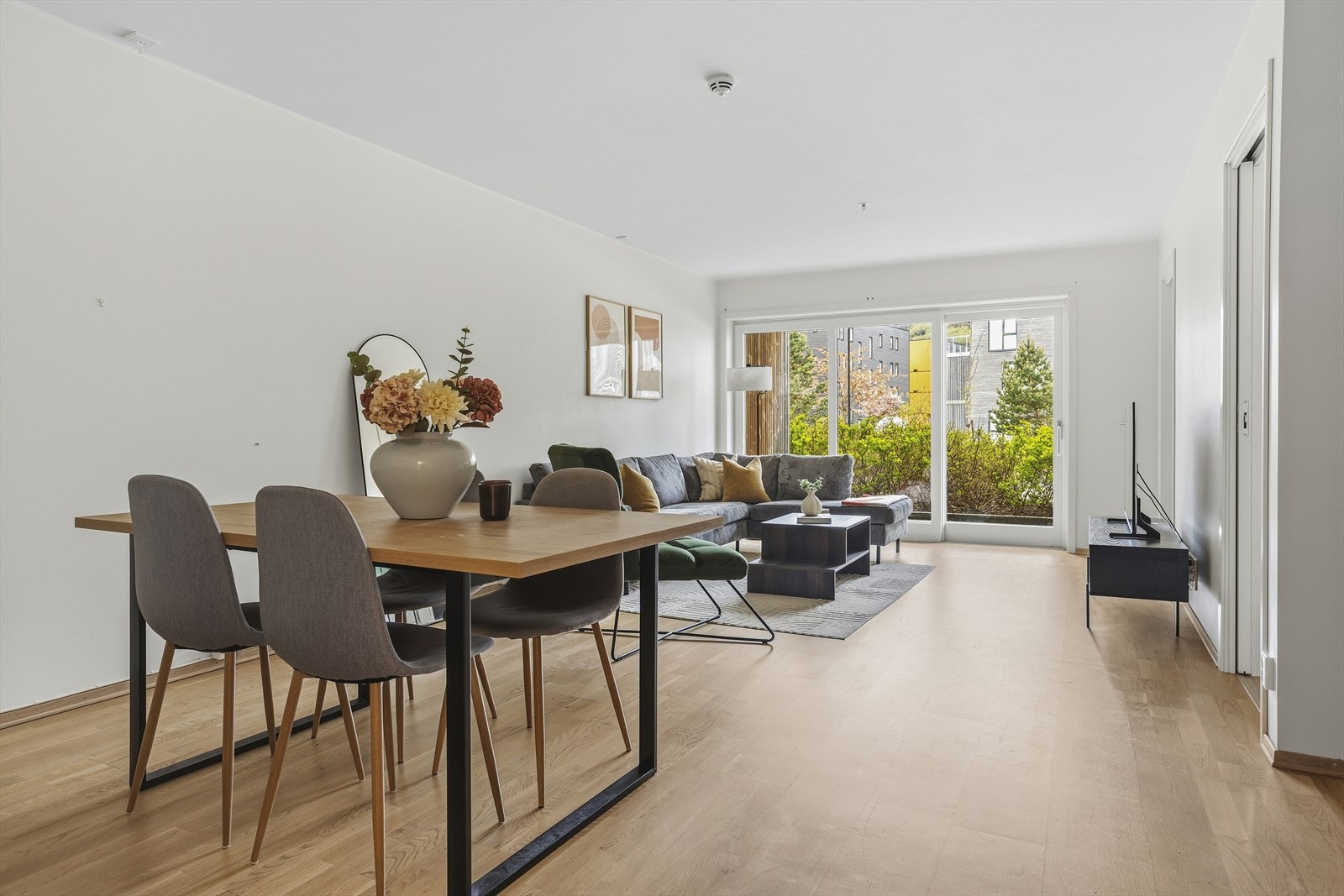 Stuen utgjør en romslig og lys del av det åpne oppholdsarealet, med store vindusflater og terrassedør i glass som slipper inn rikelig med dagslys. Galleribilde