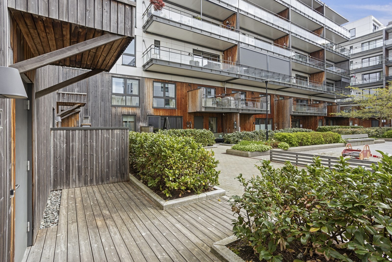 Ved inngangspartiet finner man en terrasse med plass til dekorativ beplantning. Uteplassen er skjermet av beplantning og gir rom for en hyggelig sittegruppe. Galleribilde