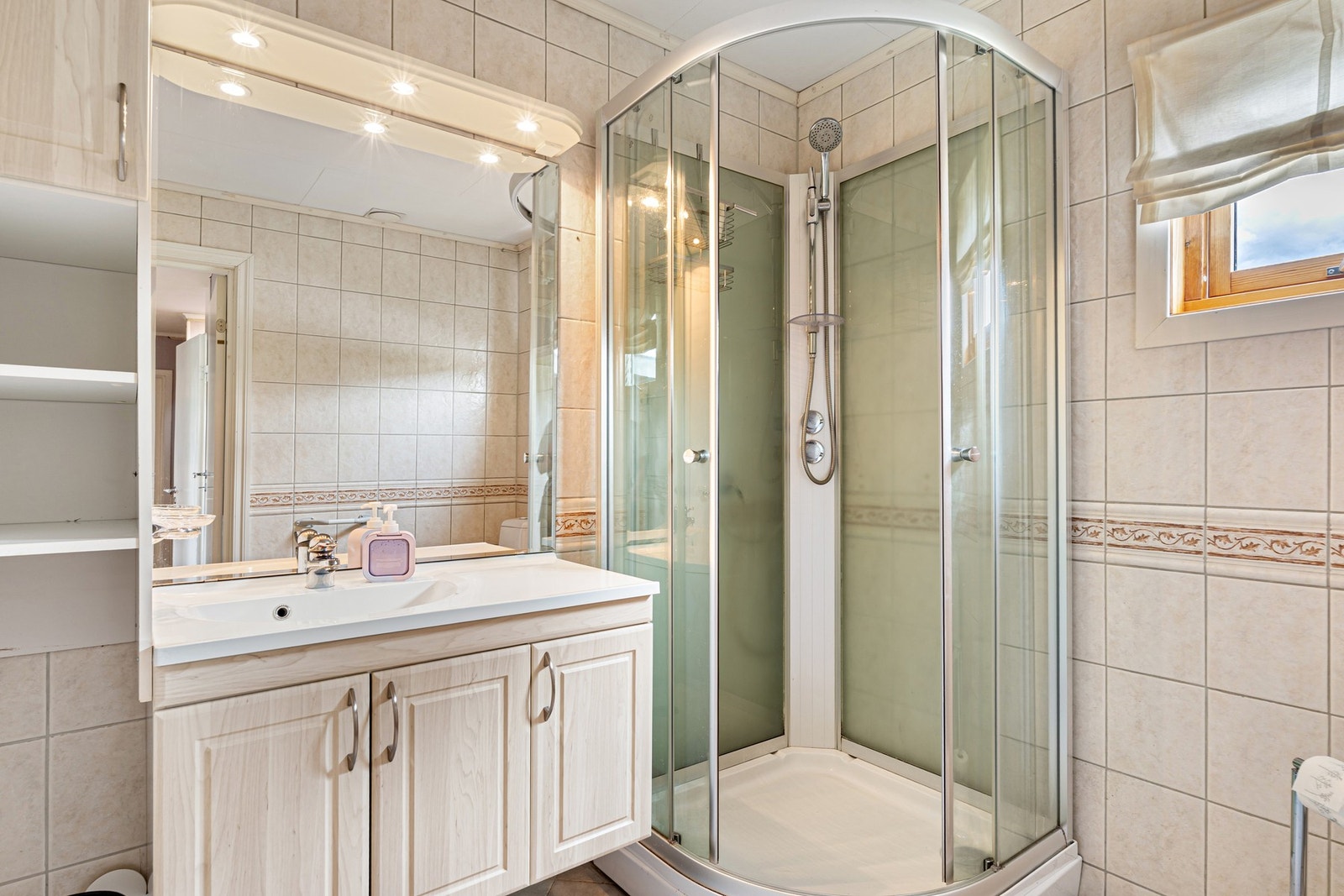 Badet er utstyrt med bl.a. dusjkabinett, servant og klosett. Galleribilde