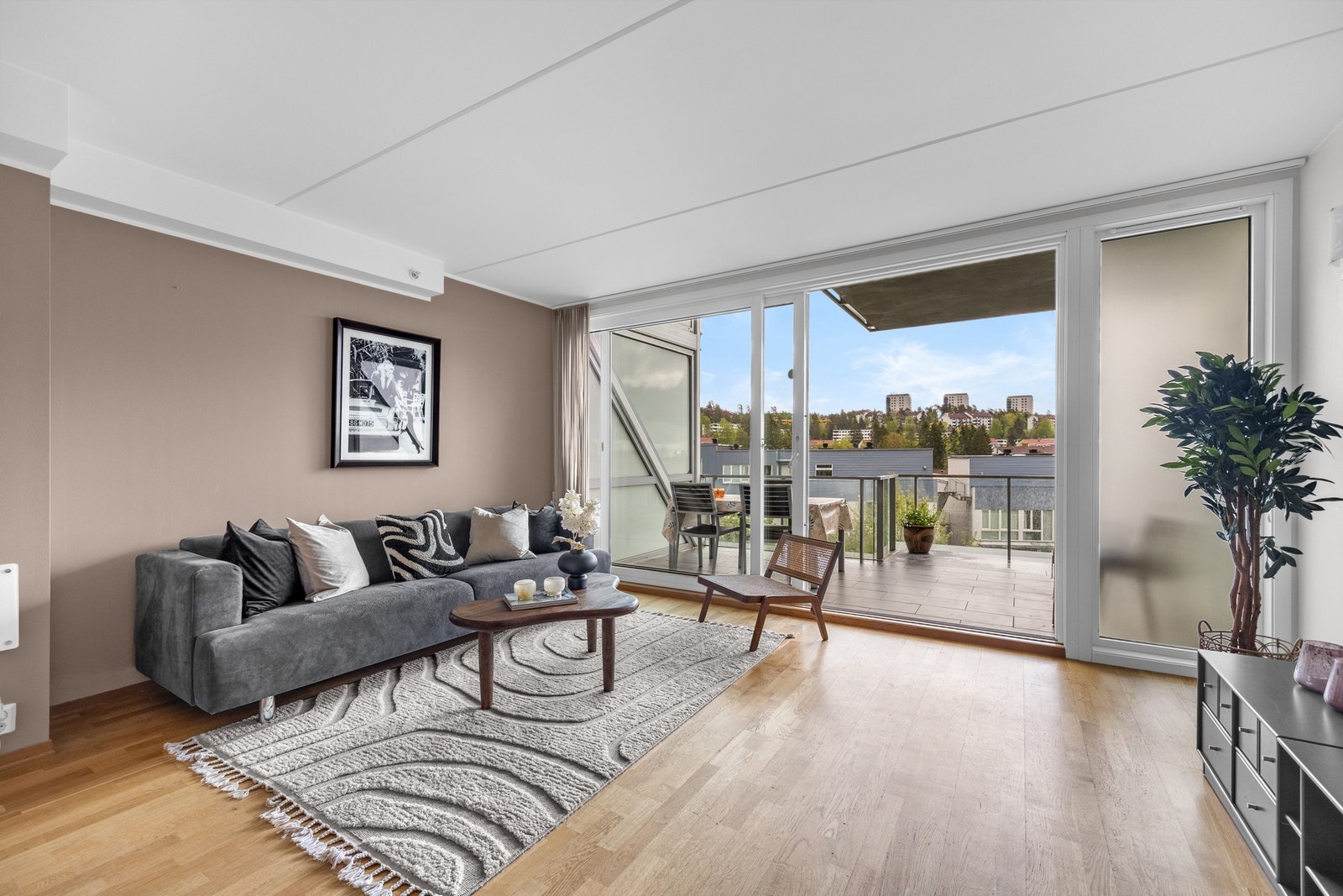 Lys, inviterende stue med store vindusflater og utgang til balkong via stor skyvedør. Galleribilde