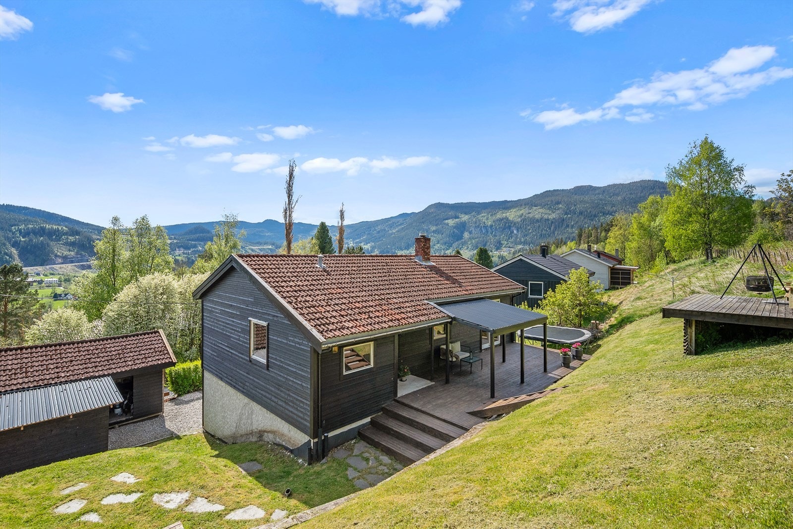 Tomten ligger høyt plassert, noe som gir en nydelig utsikt til landskapet med fjell, skog og daler. Galleribilde