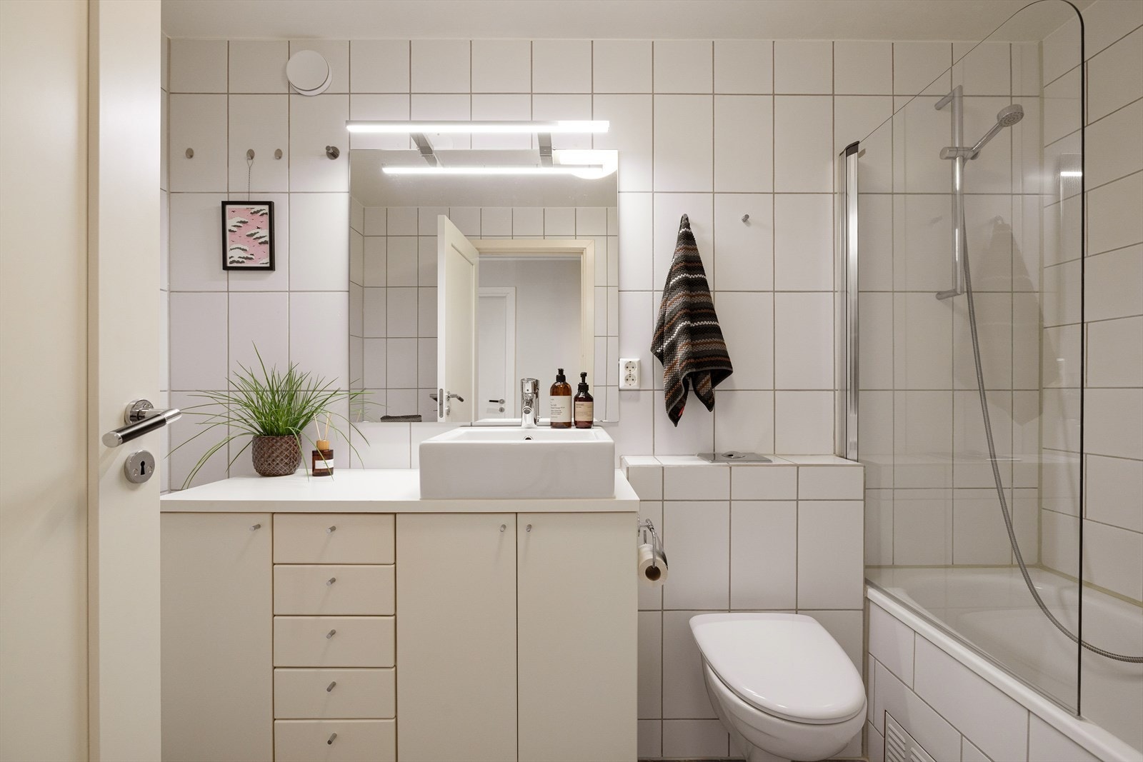 Pent flislagt bad med gulvvarme, vegghengt toalett og innebygget badekar. Galleribilde