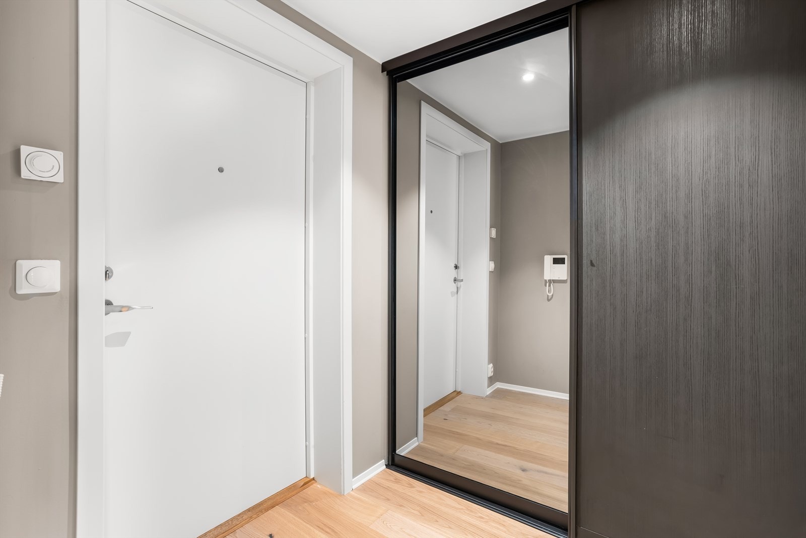 Entré med plass til yttertøy og sko i en stor skyvedørsgarderobe med speilfronter. Galleribilde