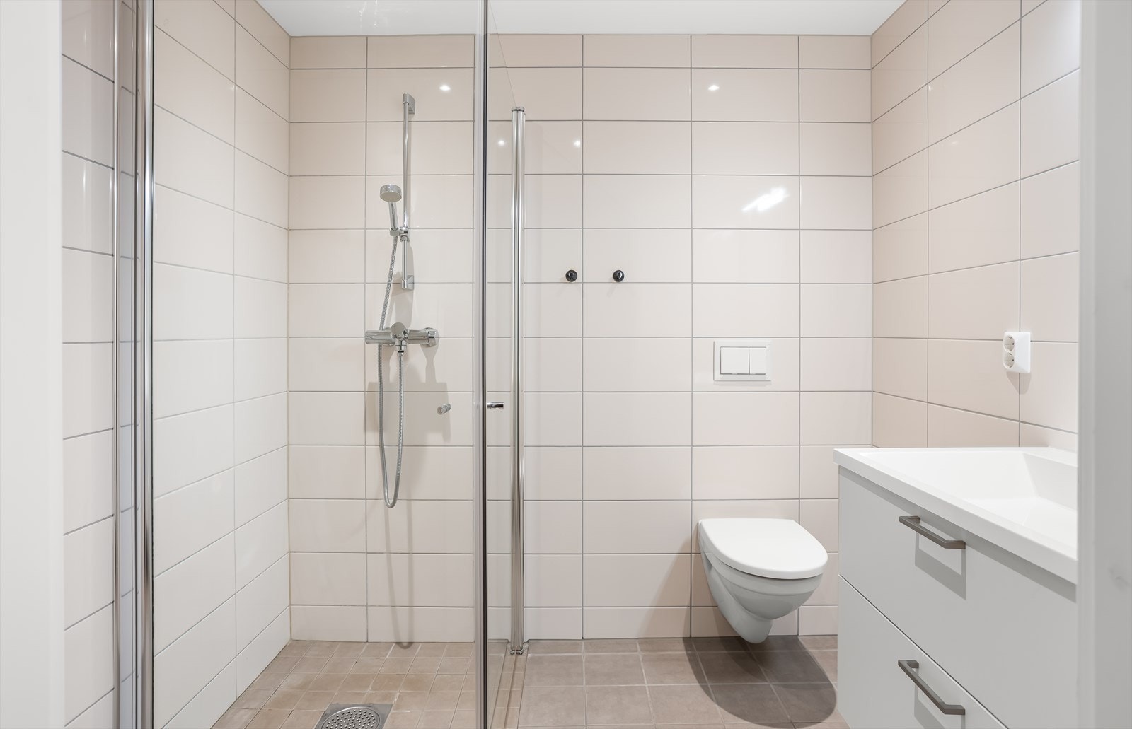 Badet har dusjhjørne med innfellbare glassdører og opplegg for vaskemaskin. Galleribilde