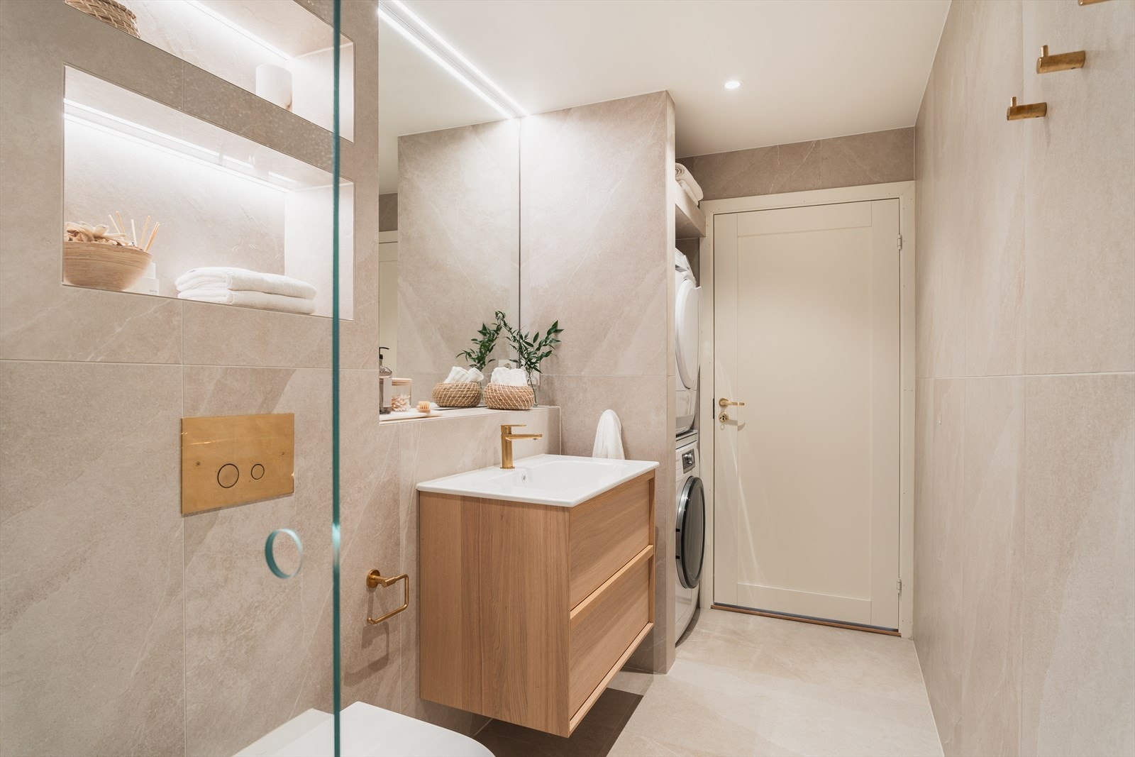 Badet har vegghengt toalett og praktisk opplegg for vaskemaskin. Galleribilde