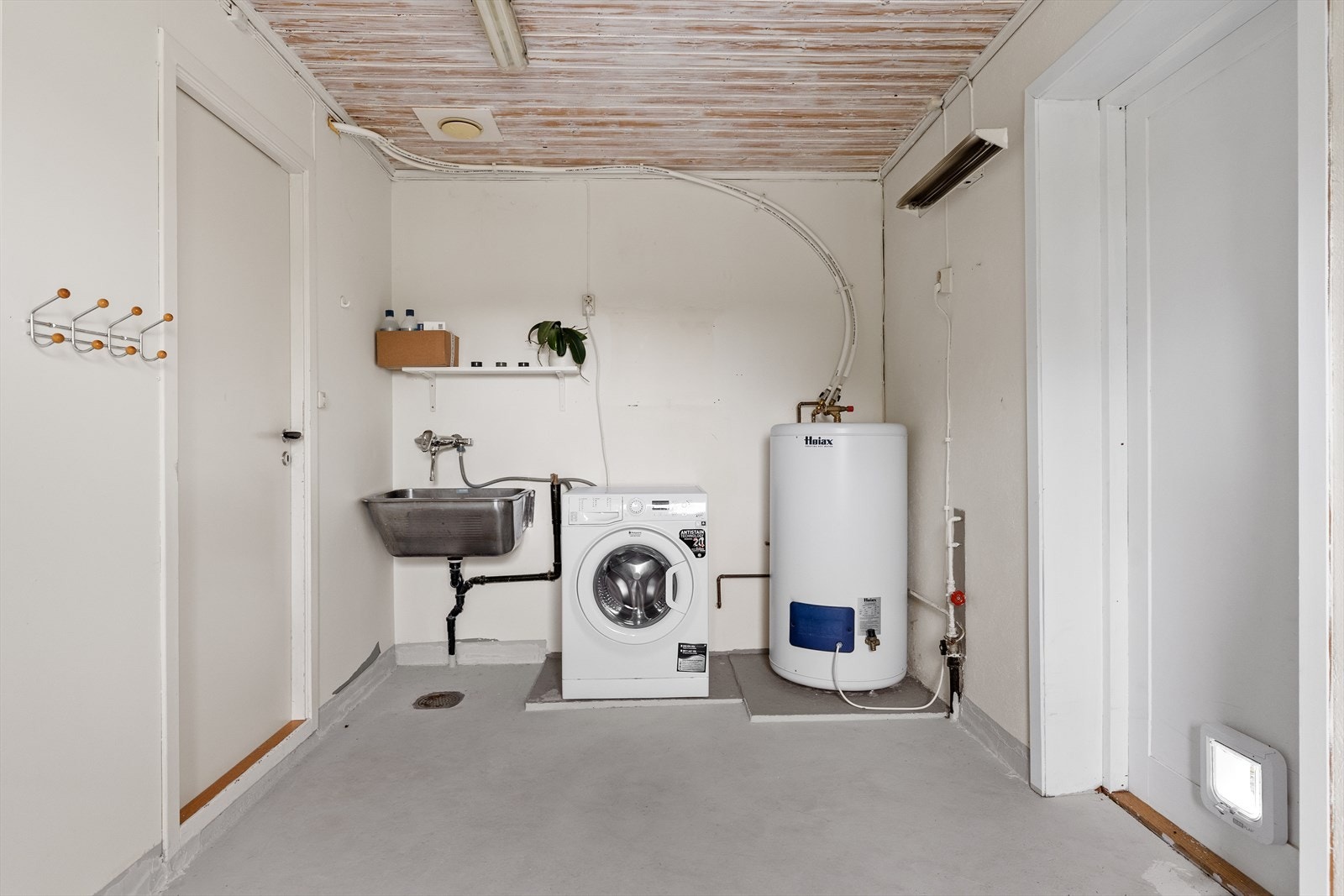 Praktisk og romslig vaskerom med opplegg for vaskemaskin, vaskekum og en 200-liters varmtvannsbereder. Galleribilde
