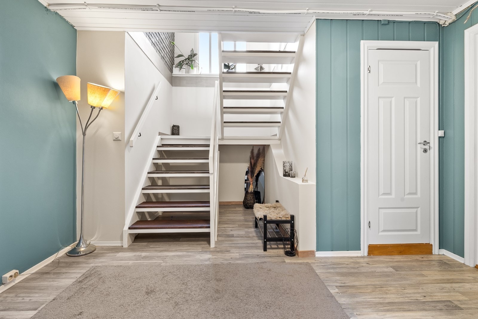 Fra stuen fører trappen ned til en romslig hall. Trappen fikk nye trinn i 2023-2025. Galleribilde