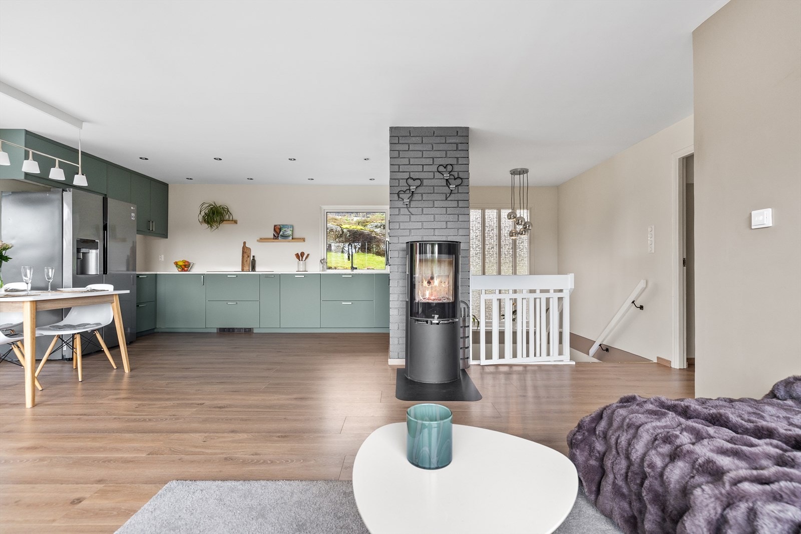 En flott peisovn er sentralt plassert i stuen og fungerer som et naturlig samlingspunkt i oppholdsrommet. Peisovnen tilfører både behagelig varme og en lun atmosfære, samtidig som den skaper et elegant og moderne uttrykk i rommet. Galleribilde
