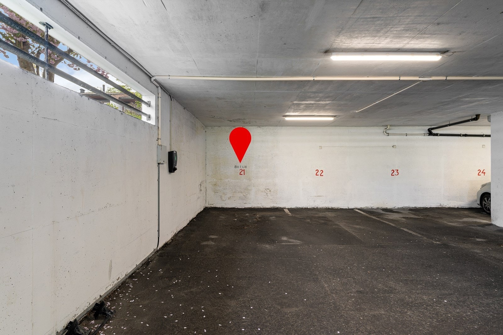 Fast parkeringsplass i lukket anlegg med el-bil lader. Galleribilde