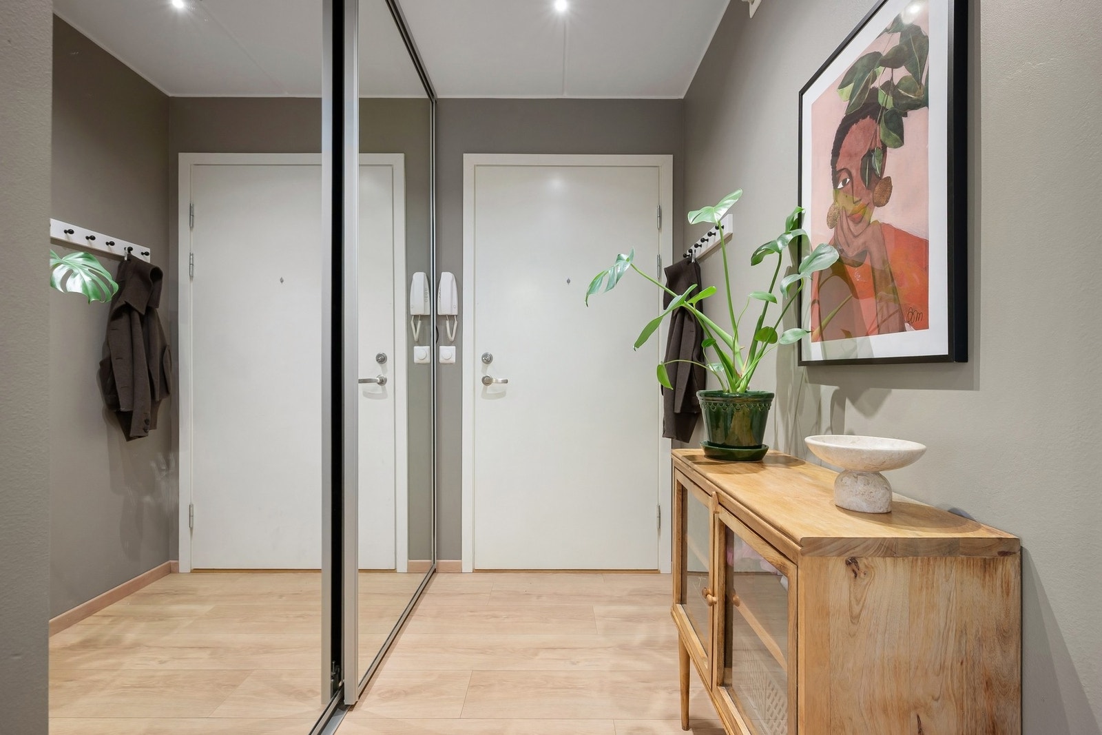 En lys og praktisk entré med god plass til oppbevaring. Her er det montert en stor skyvedørsgarderobe som gir rikelig med lagringsplass og bidrar til et ryddig uttrykk. Galleribilde
