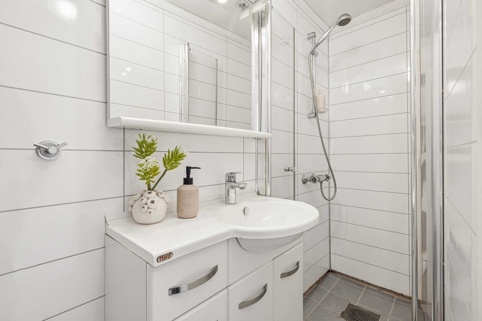 Badet har belegg på gulvet og malte plater på veggene. Galleribilde