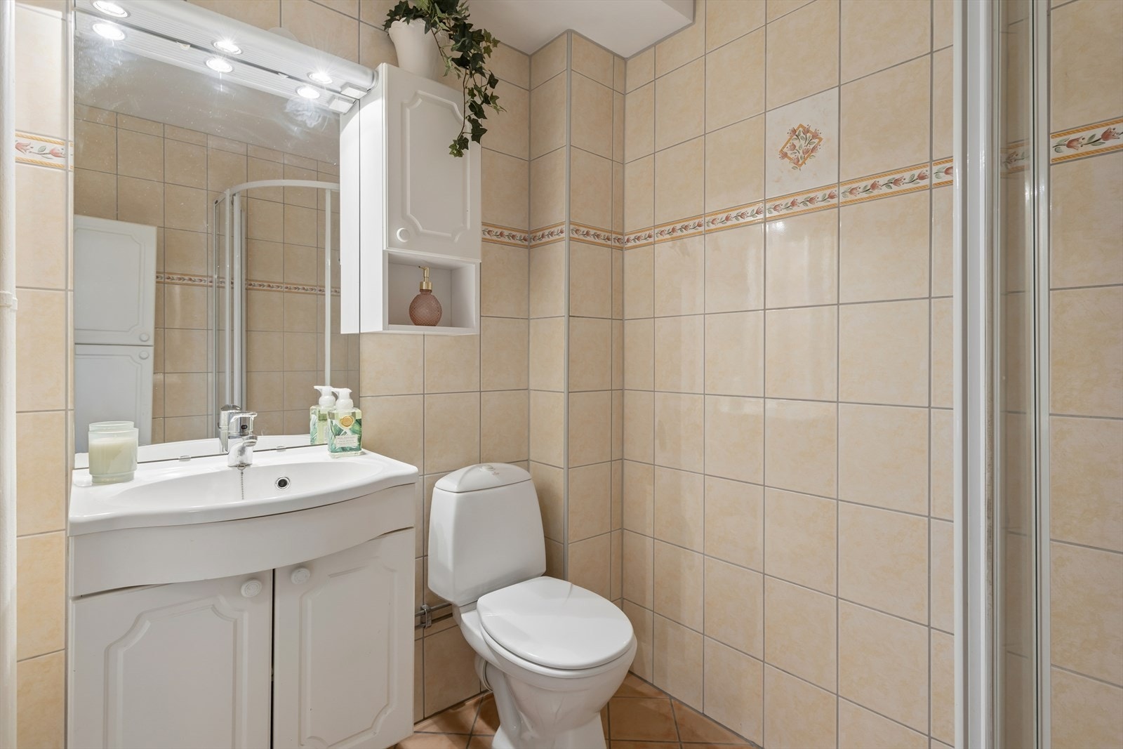 Baderomsinnredning med nedfelt servant og speilskap. Badet har mekanisk avtrekk. Galleribilde