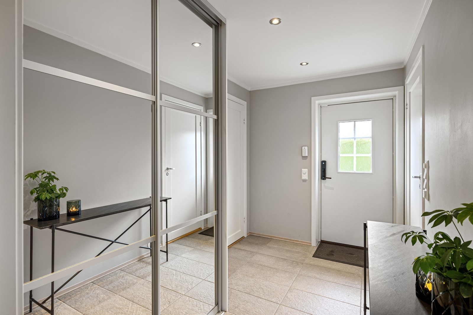 Vel inne i entréen er det god plass til å henge fra seg yttertøy og sette fra seg sko. Det er montert en romslig skyvedørsgarderobe med speilfronter. Galleribilde