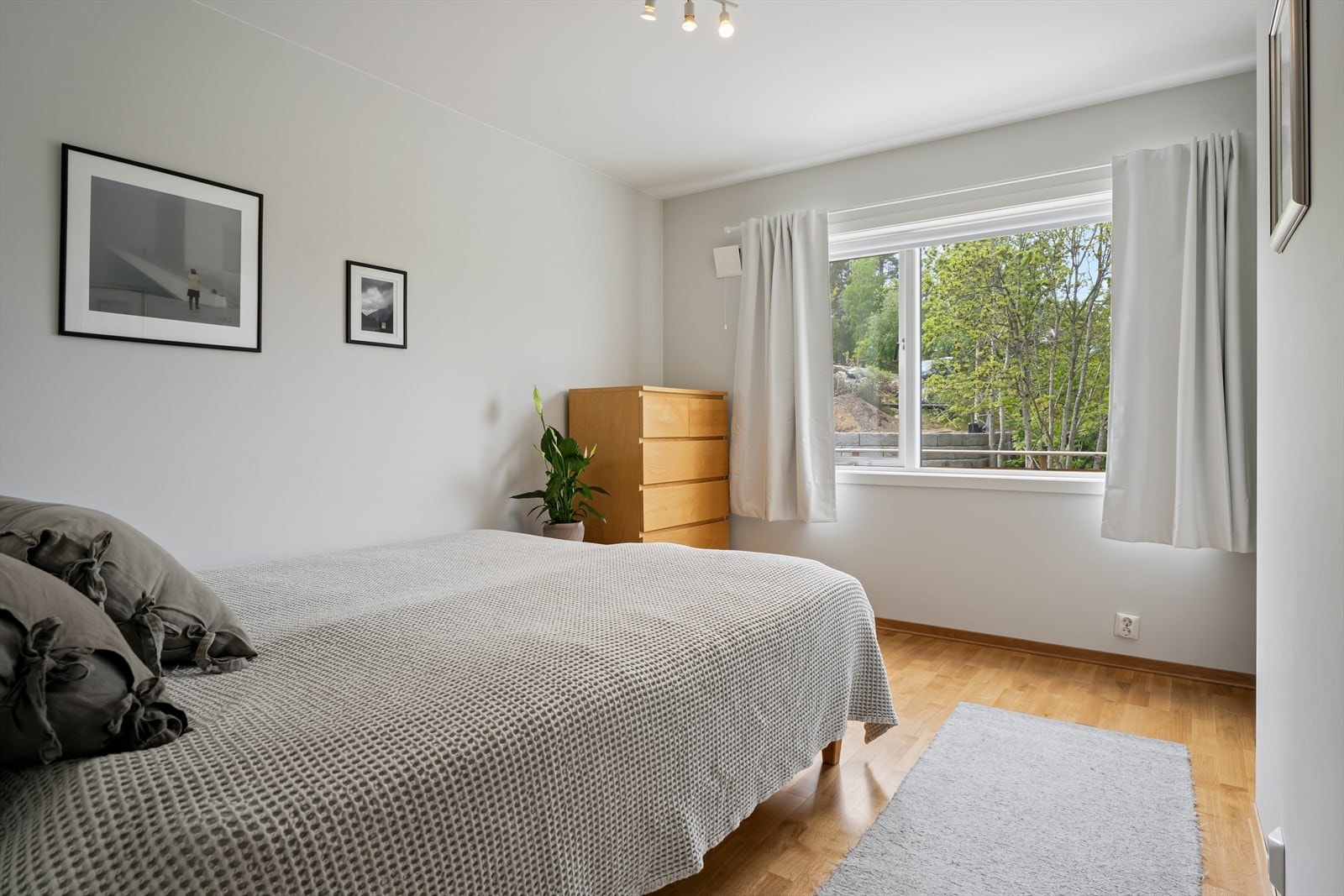 Ett av tre soverom i første etasje. Etasjen fremstår helhetlig med parkettgulv fra 2019 og behagelig gulvvarme. Galleribilde