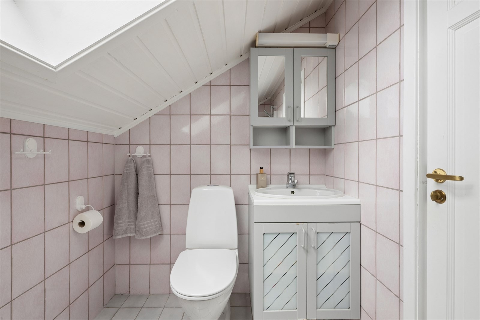 Bad fra byggeår i tilknytning til soverommene, innredet med klosett, servant med innredning samt badekar med dusj og glassvegg. Galleribilde
