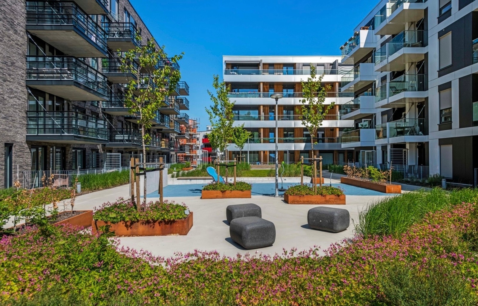 Sameiet har et flott fellesareal, pent opparbeidet med plener, benker, plantekasser og stemningsfull belysning Galleribilde