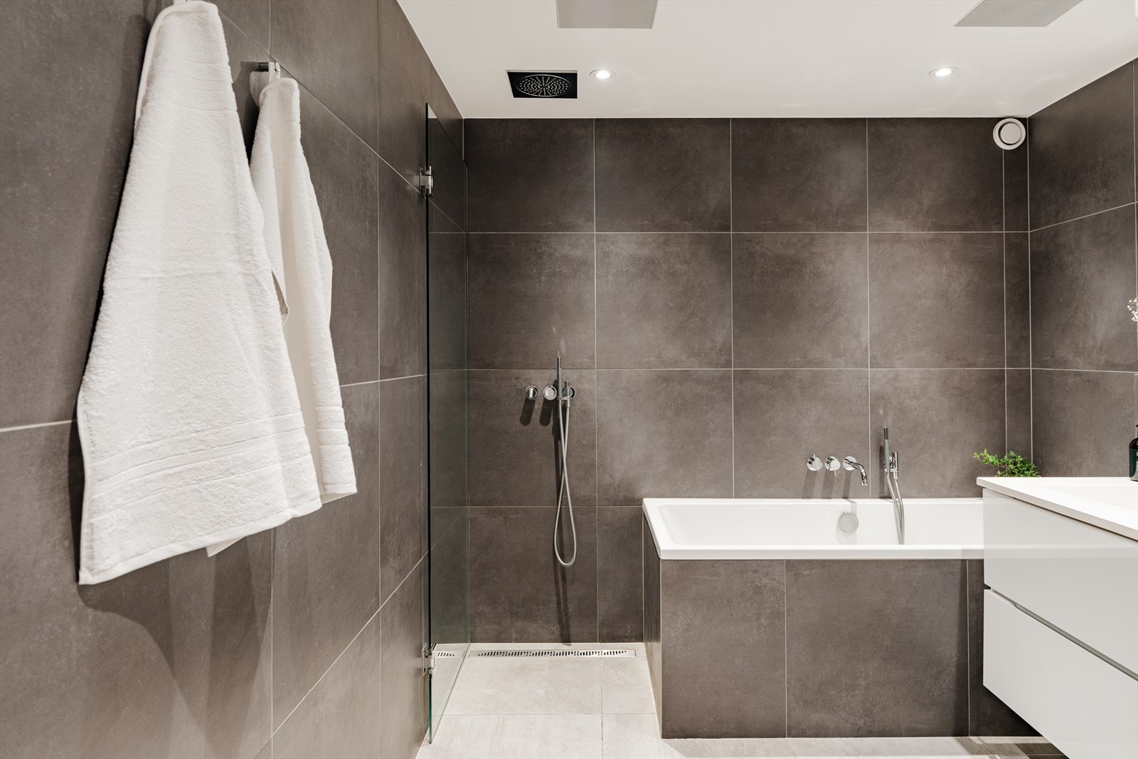 Boligens bad er delikat flislagt i moderne fargepaletter med varmekabler i gulvet. Badet ble oppgradert i 2014 og har moderne innredning med hvite, høyglans fronter og heldekkende servant. Galleribilde