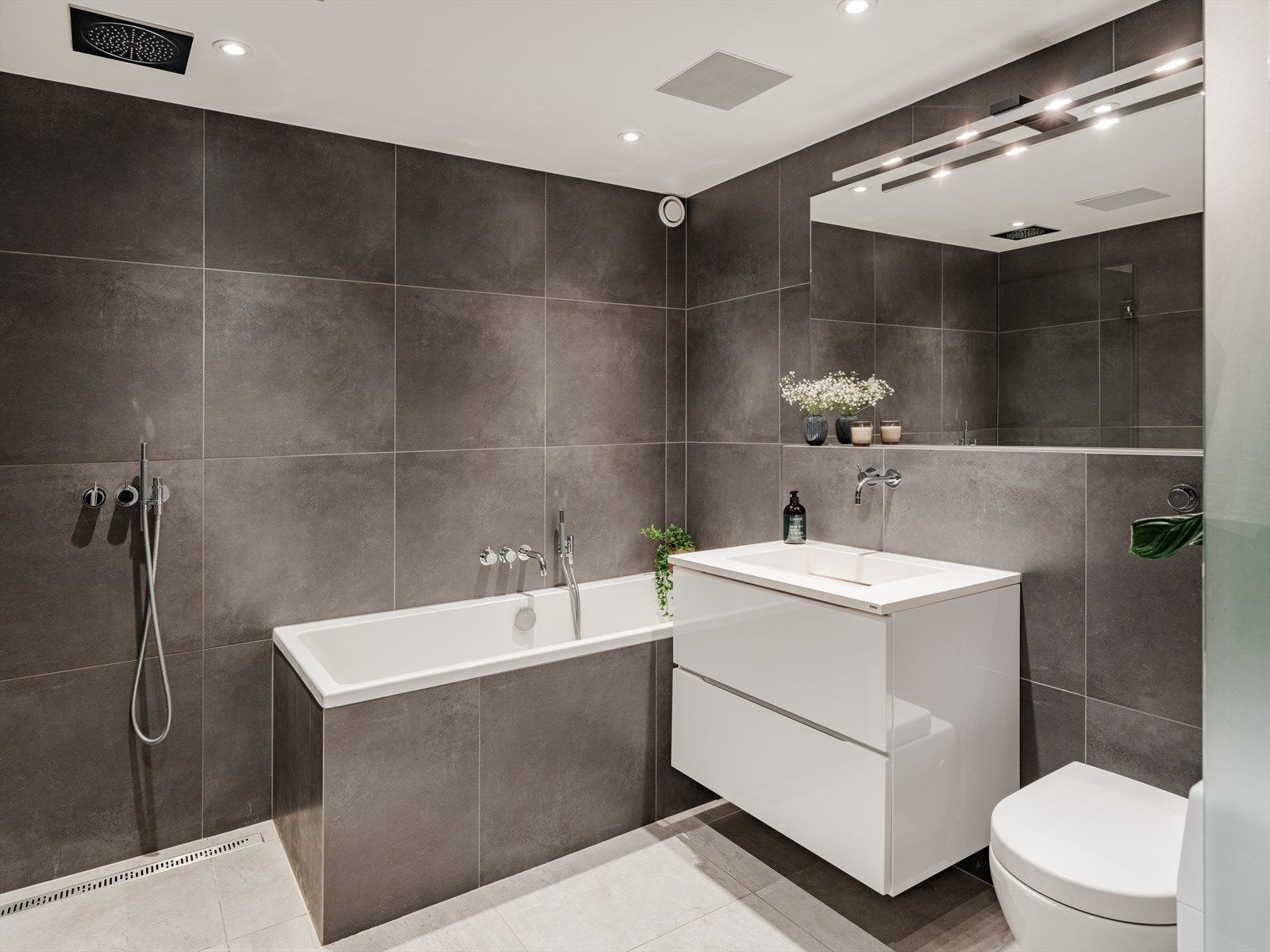 Etter en lang og stressende dag kan du slappe av med et varmt bad i det innflisede badekaret. Badet har ellers vegghengt toalett og opplegg for vaskemaskin. Galleribilde