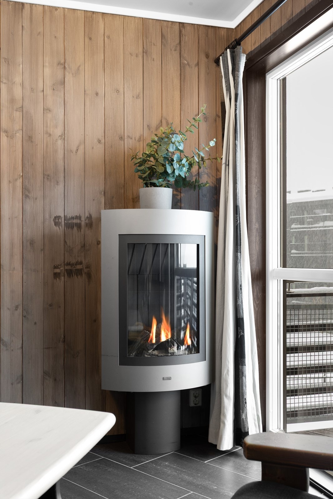 Leiligheten har en gjennomgående stil med trepanel på veggene og en peis i stuen som gir en lun atmosfære. Galleribilde