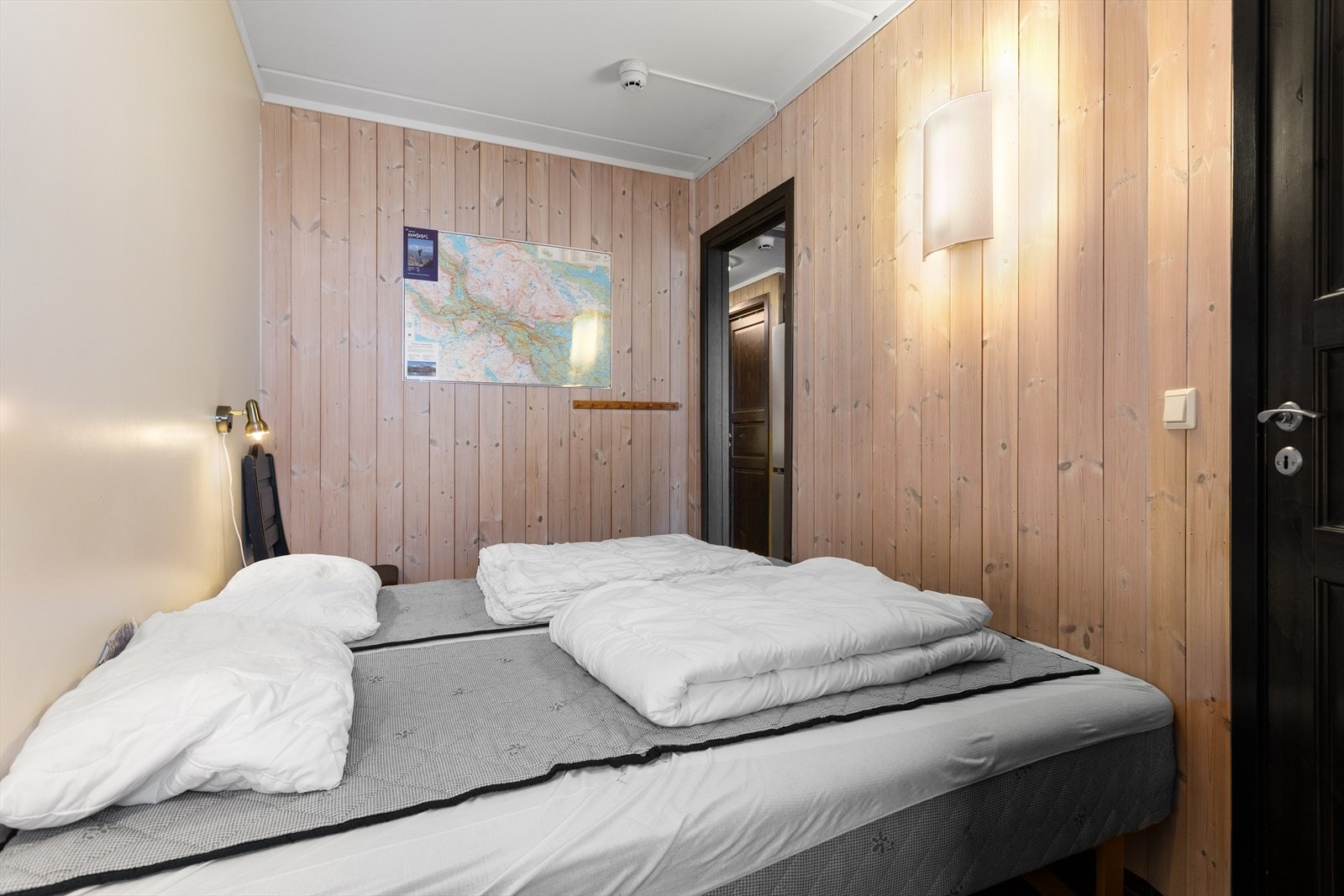 Det ene av leilighetens to soverom, innredet med sengeplasser og kledd med trepanel. Galleribilde