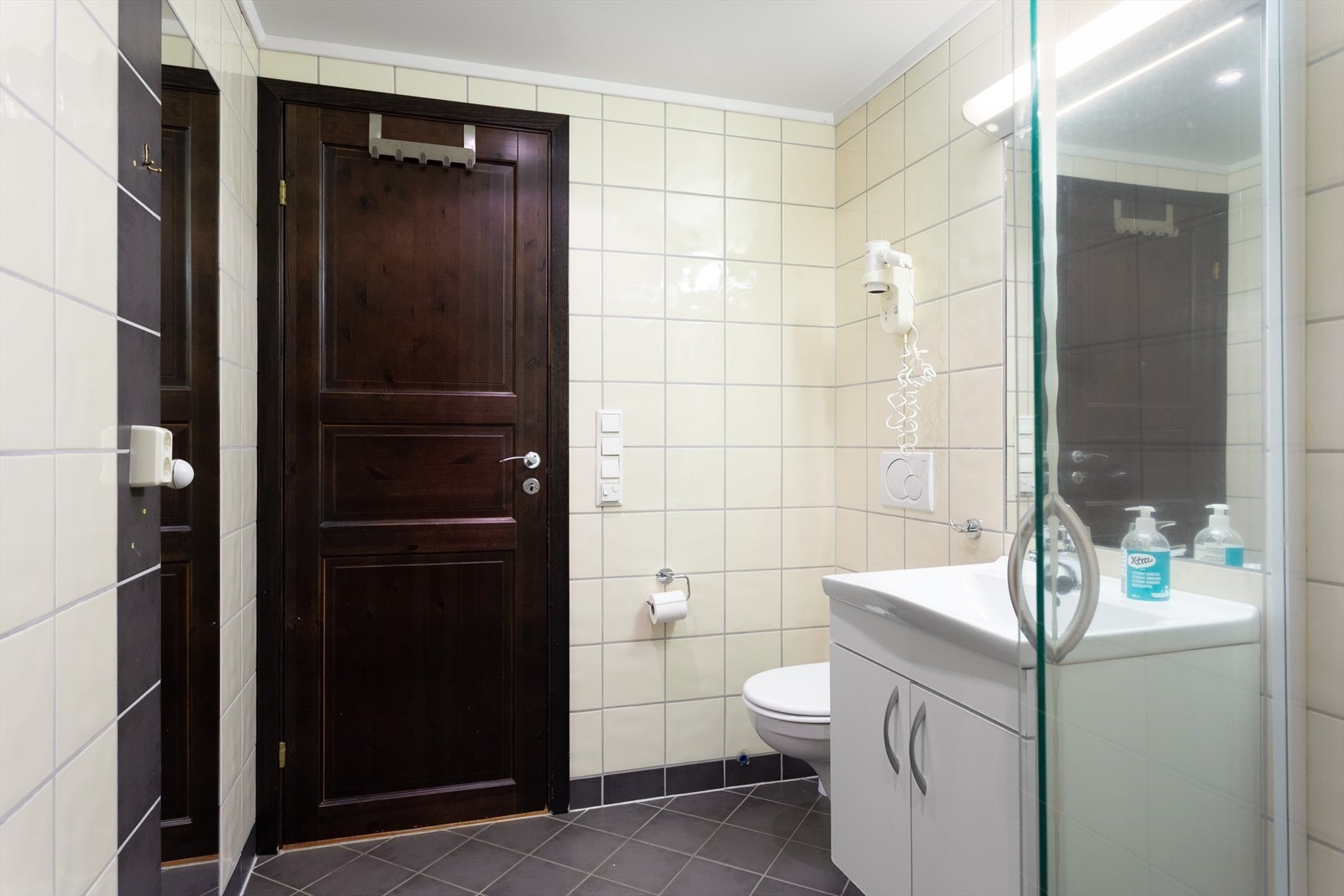 Praktiske løsninger på badet med fliser på vegg og gulv. Galleribilde