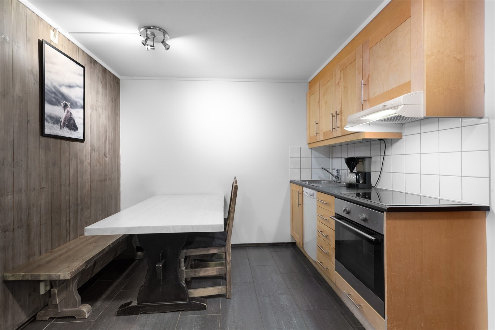 Kjøkkenet har en praktisk plassering i leiligheten, med spiseplass og profilerte fronter på innredningen. Galleribilde