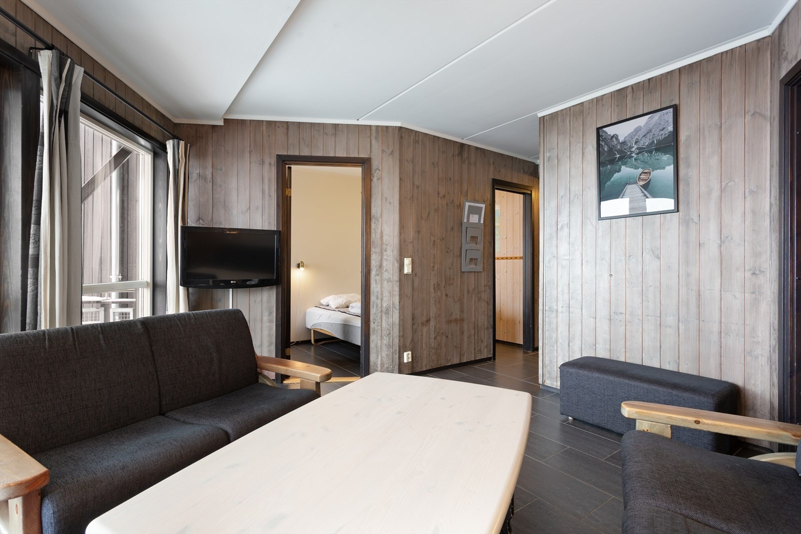 Stuen har god plass til en sofagruppe og gir tilgang til leilighetens to soverom. Galleribilde
