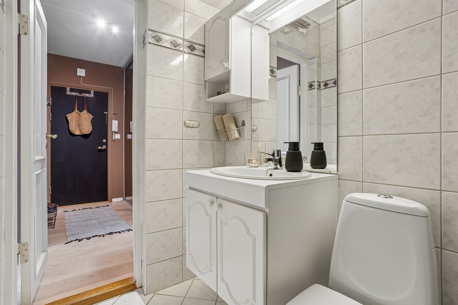 Badet har flislagt gulv og vegger, og er utstyrt med toalett og helstøpt servant med underskap. Galleribilde
