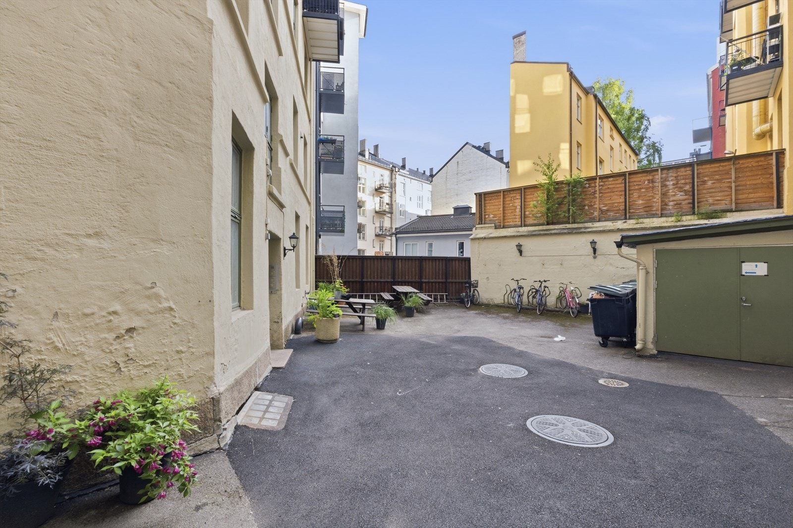 Indre gårdsrom med asfalterte flater, sittegruppe og sykkelparkering Galleribilde