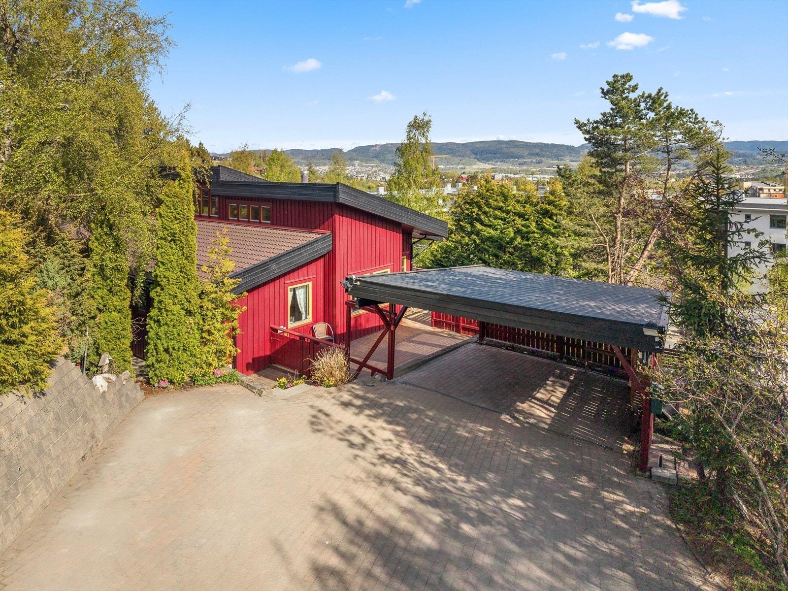 Steinbelagt gårdsplass med med nyoppsatt mur med integrerte lys. Stor dobbel carport med lys og god plass til flere biloppstillingsplasser Galleribilde