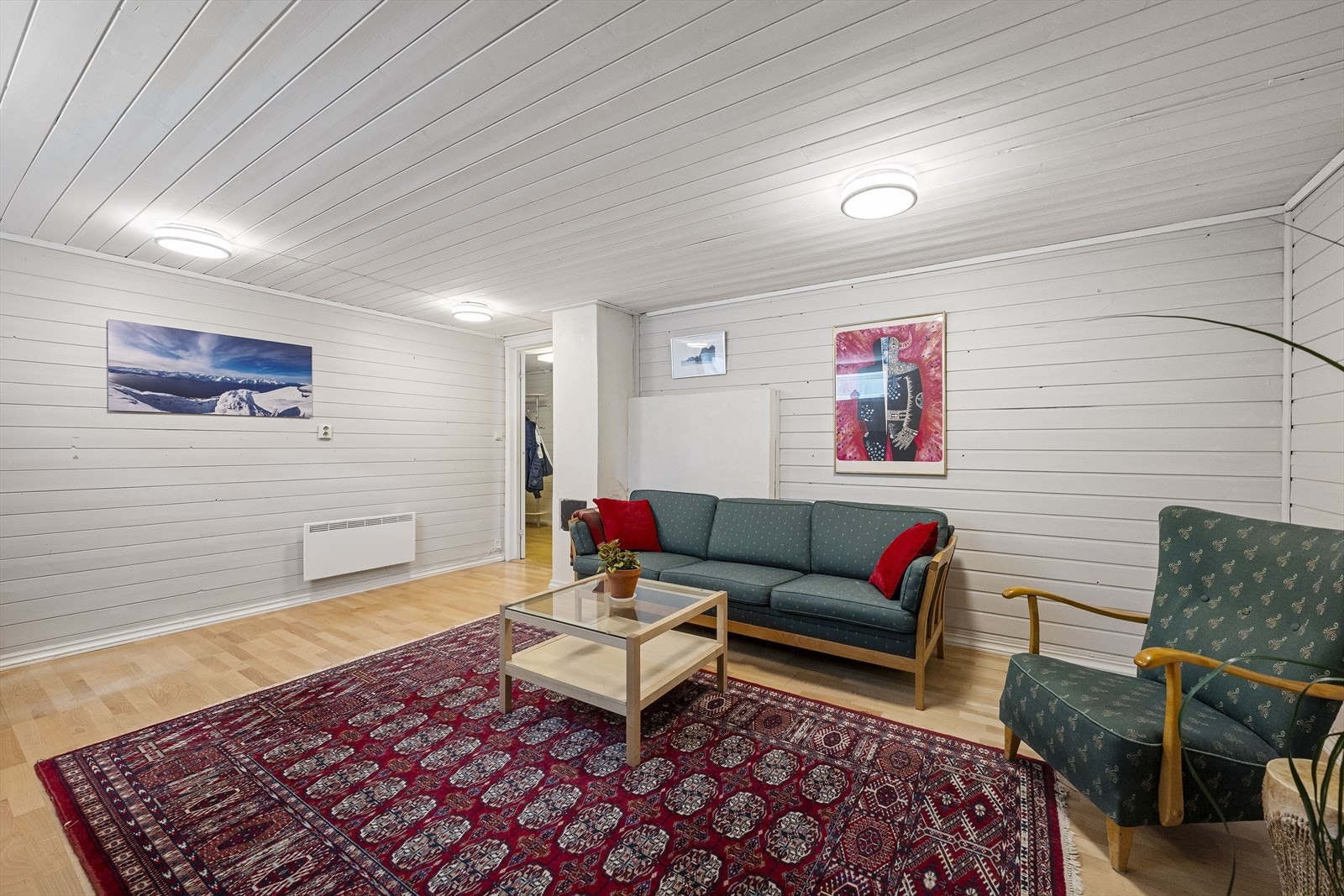 Innredet rom i kjelleren med panel på vegger og tak. Rommet egner seg godt som en ekstra stue. Galleribilde