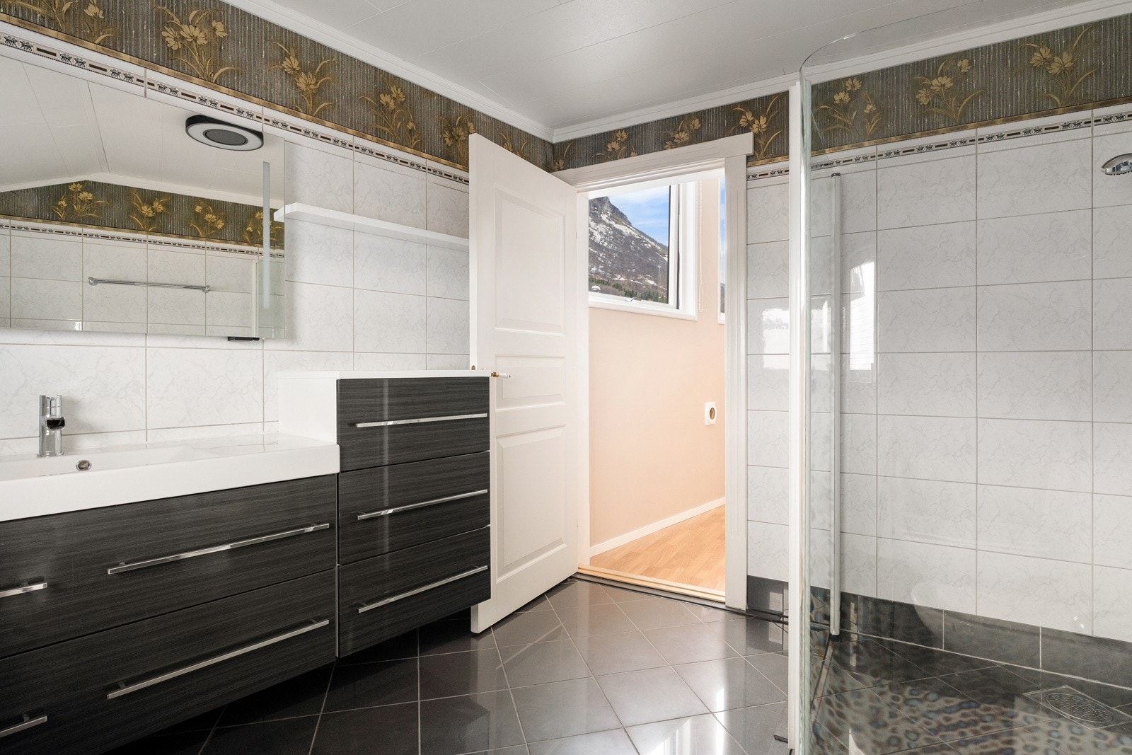 Flott flislagt bad med stor innredning for lagring av baderomsartikler. Galleribilde