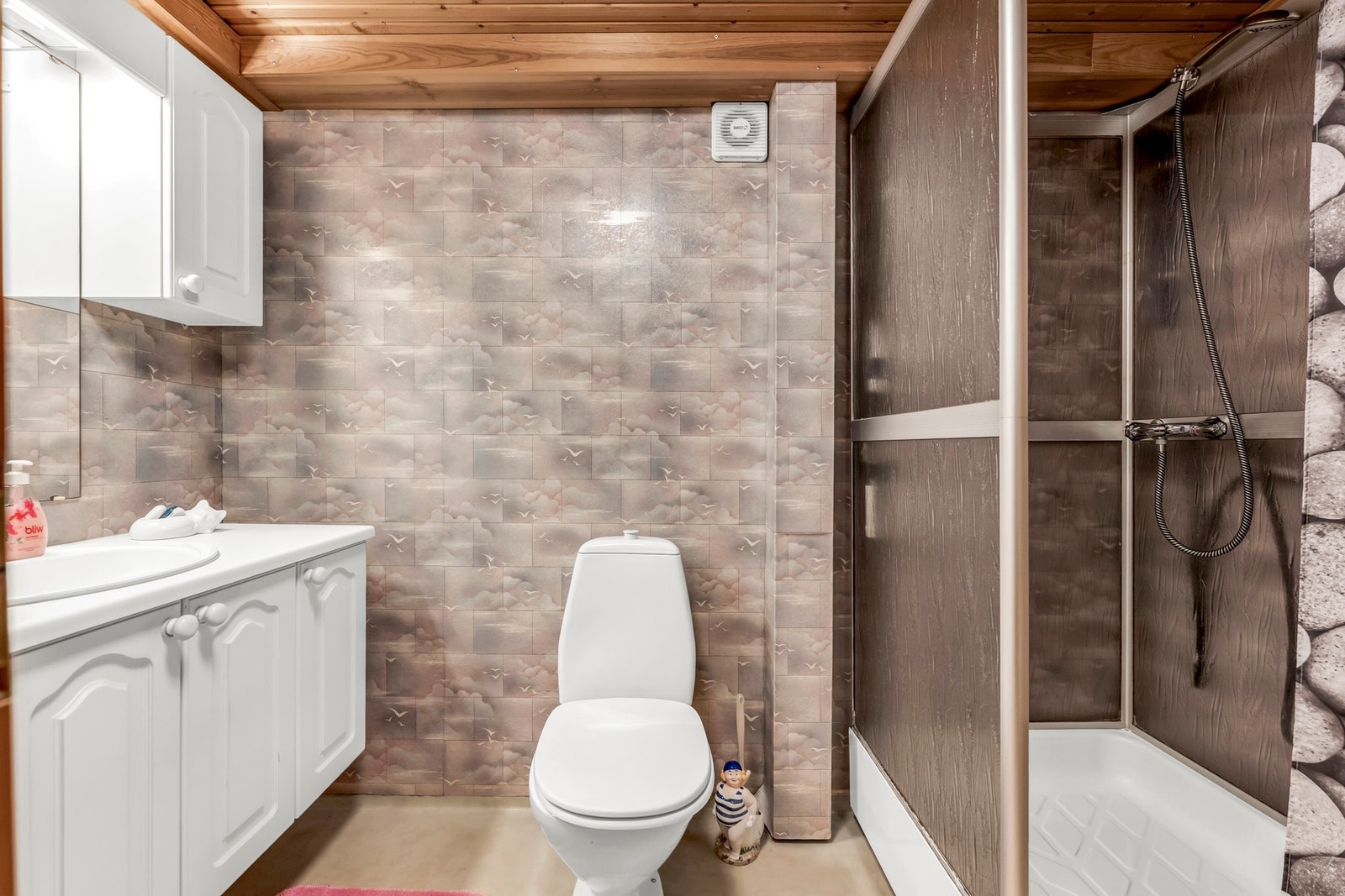Badet er innredet med en stor innredning med gode oppbevaringsmuligheter, toalett og dusjkabinett Galleribilde