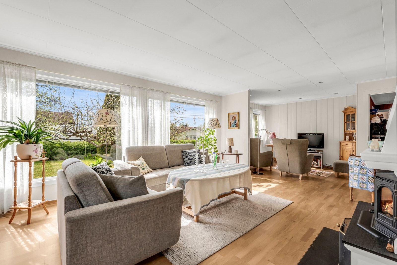 Stuen har store vindusflater som skaper rikelig med naturlig lys Galleribilde
