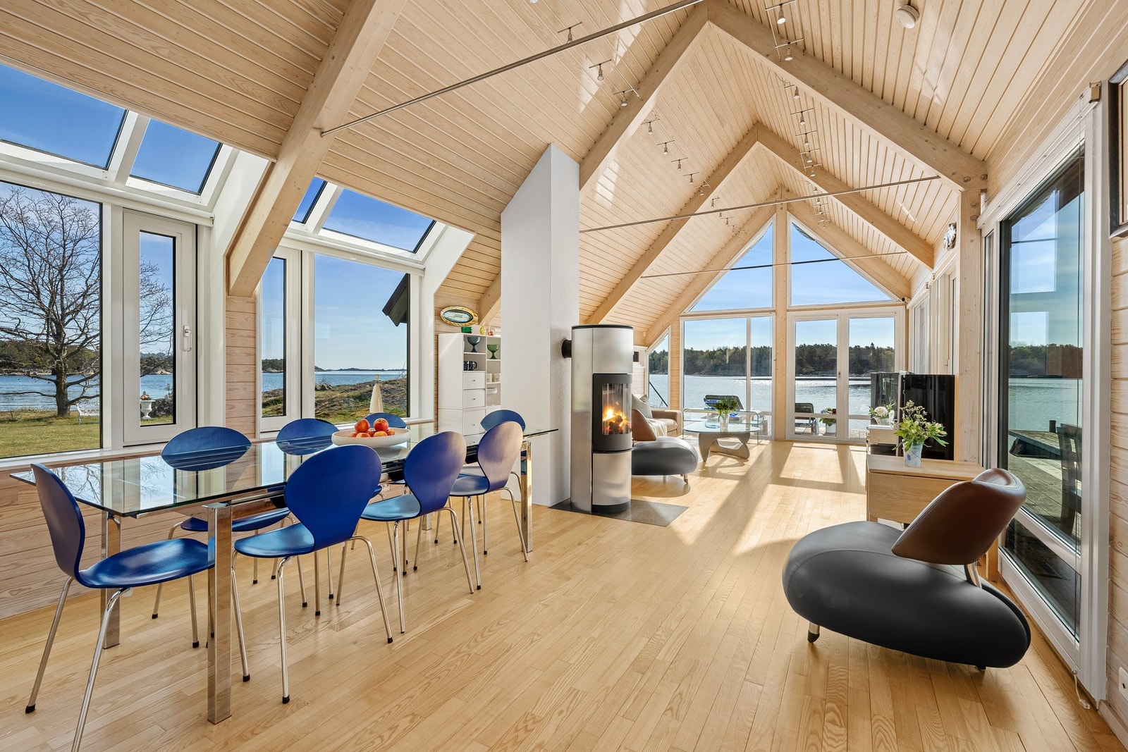 Fra den kombinerte stuen/spisestuen med åpen himling og mange vinduer vendt ut mot sjøen Galleribilde