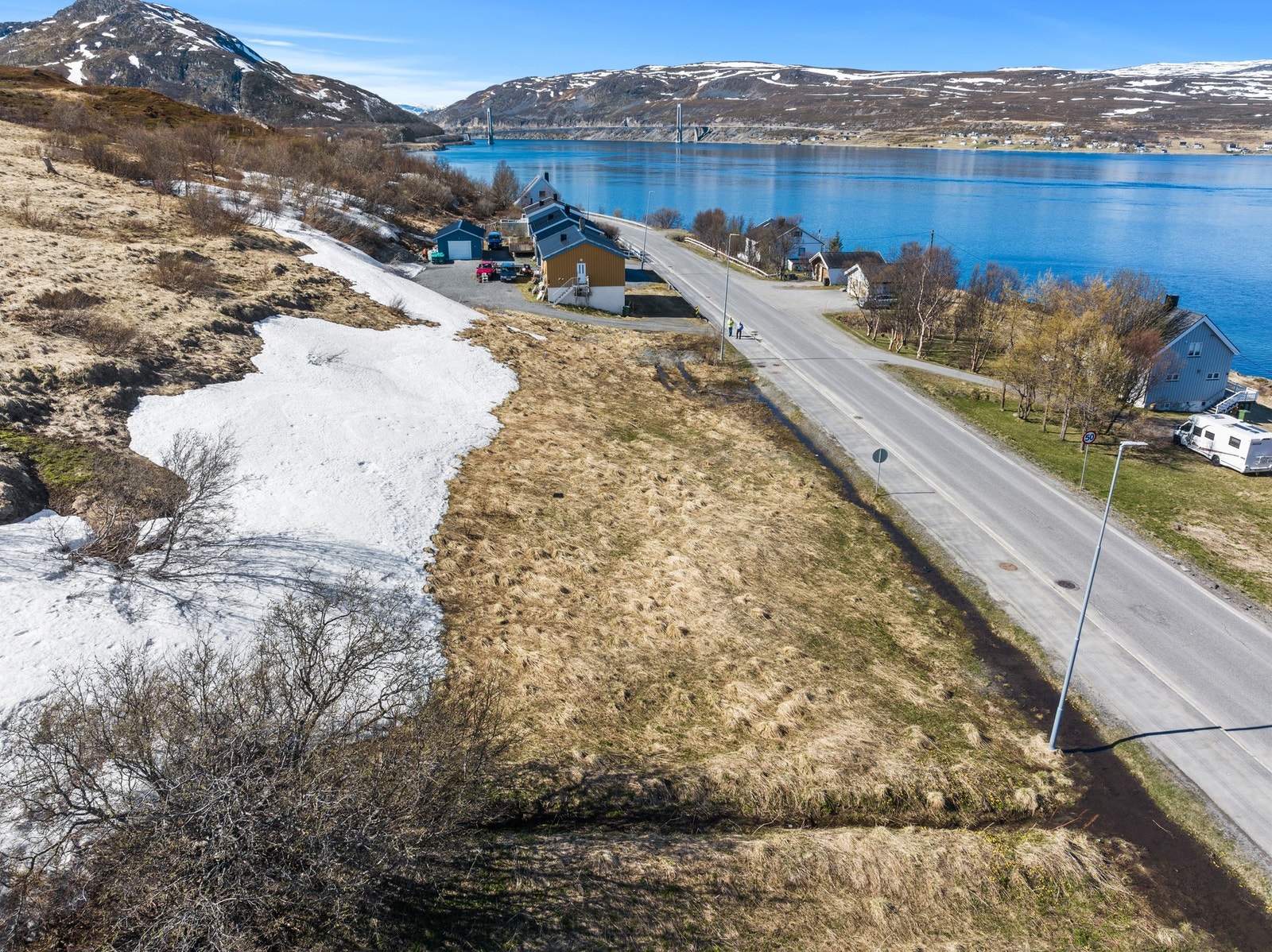 Tomten er plassert i et område med spredt bebyggelse og nærhet til fjell og fjord. Galleribilde