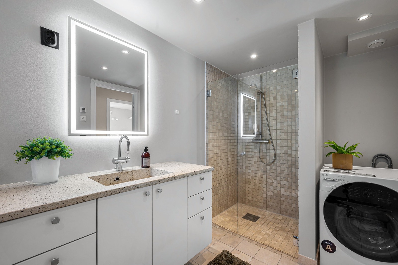 Badet er romslig og har både badekar og dusjhjørne. Opplegg for vaskemaskin. Galleribilde