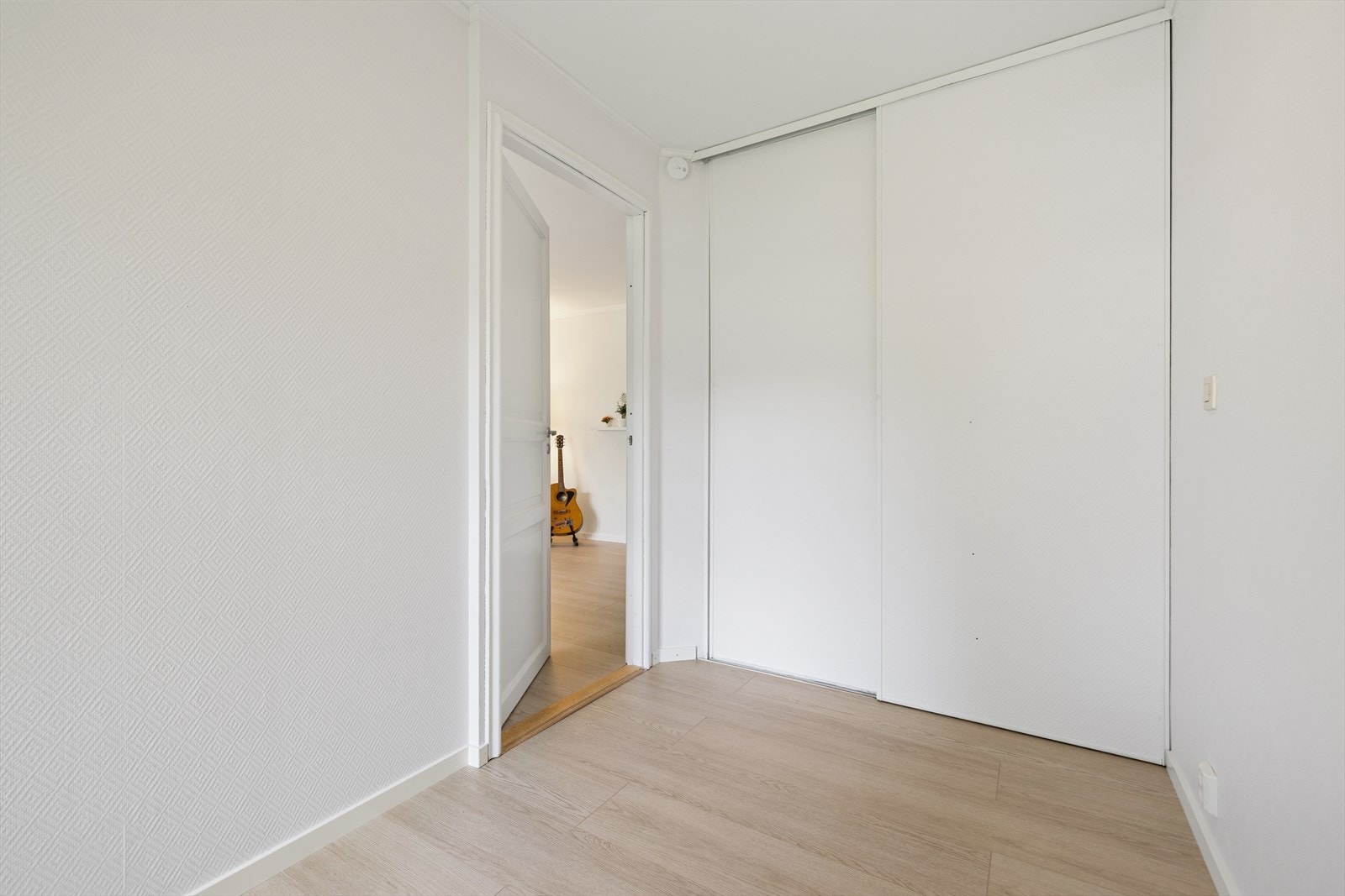 Oppbevaringsplass i skyvedørsgarderobe med tapetserte fronter. Galleribilde