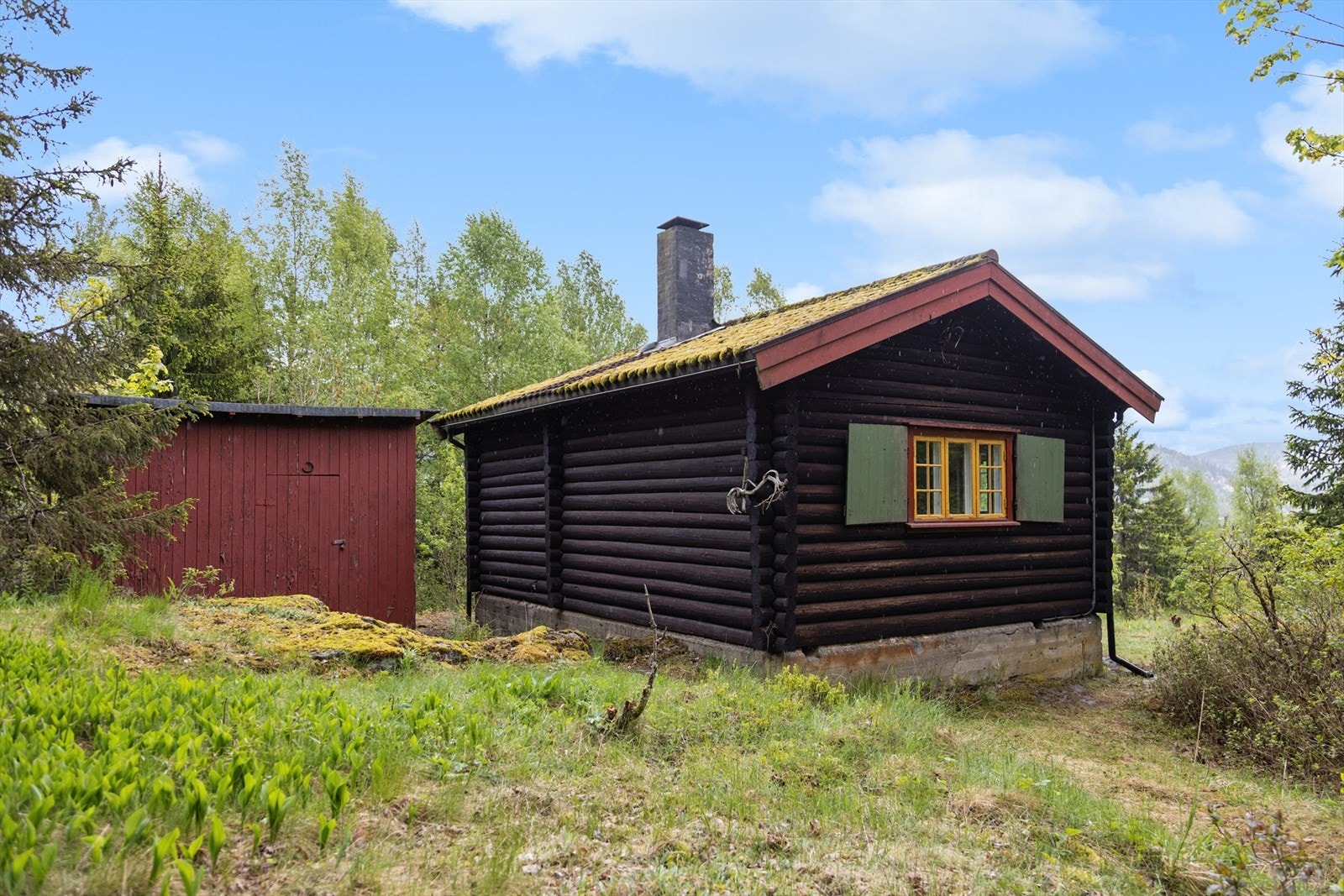 På baksiden av hytta ligger den gamle utedoen som i dag benyttes som bod Galleribilde