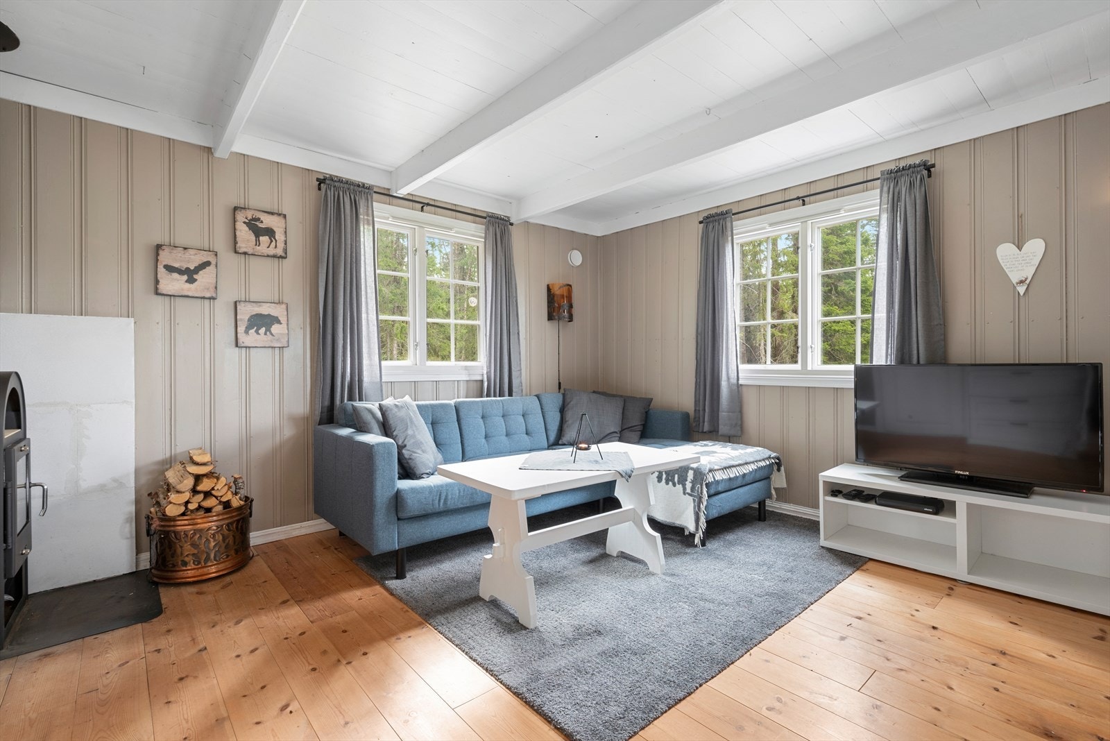 Dagslyset strømmer inn via store sprossevinduer i tre himmelretninger i stuen. Galleribilde